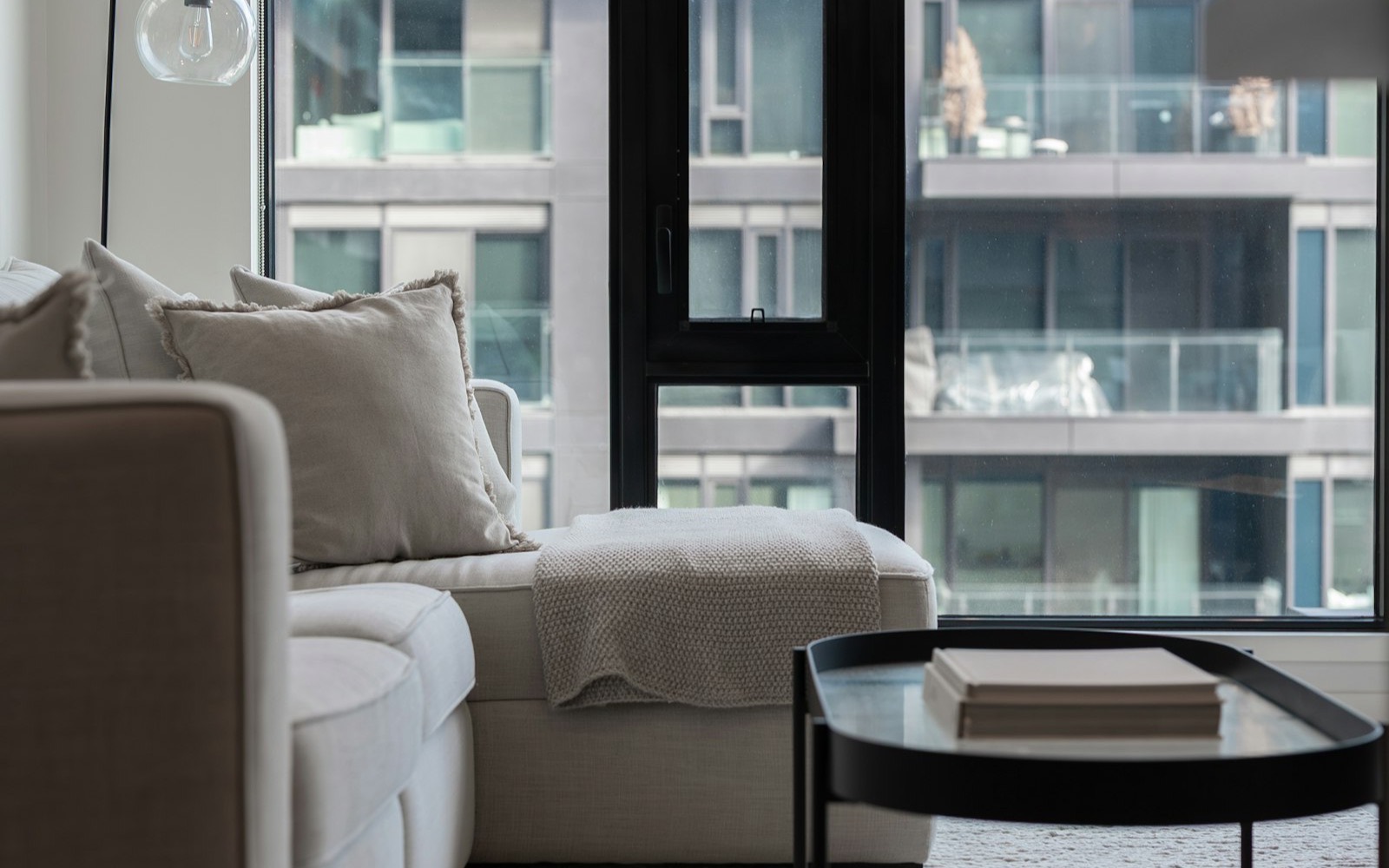 Neutral modern apartment living room with floor to ceiling windows